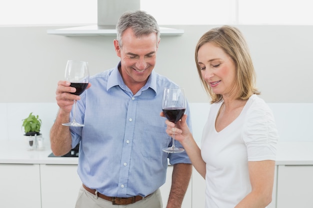 Couple d&#39;amoureux avec des verres à vin dans la cuisine