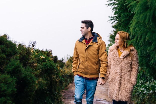 Le Couple Amoureux En Vestes Chaudes Se Tient La Main Et Monte Le Chemin