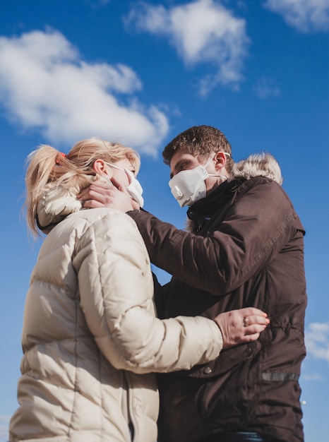 Couple amoureux en vestes et masques médicaux