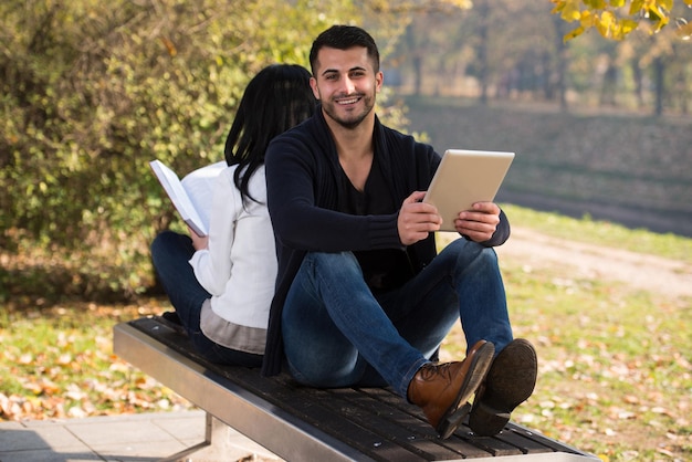 Couple Appréciant Livre Et Tablette Numérique Touchpad