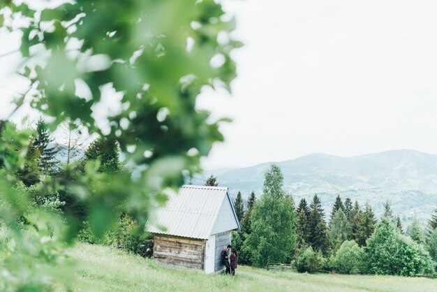 Couple appuyé sur une maison au milieu de la forêt