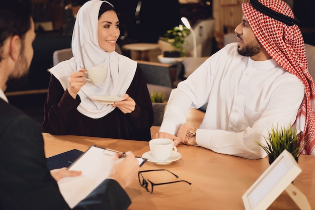 Un couple arabe boit du café à la réception du thérapeute.