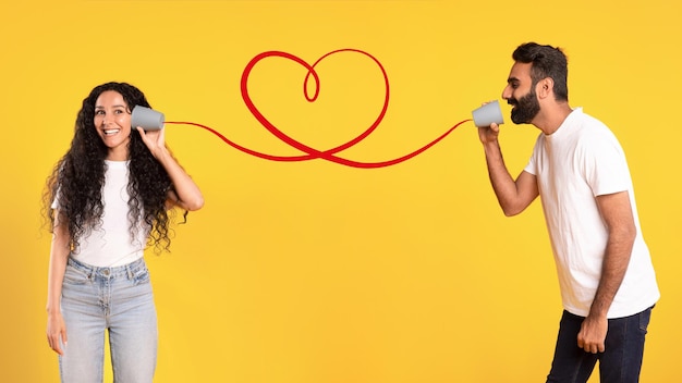 Couple arabe parlant via un téléphone en fer blanc connecté par Heart Studio