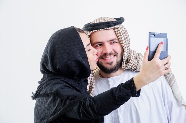 Un couple arabe prend des photos de lui-même avec un téléphone de vente.Selfie.