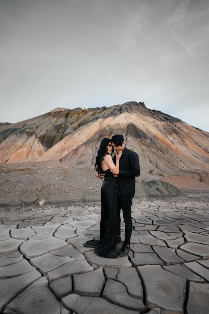 Un couple asiatique amoureux dans des vêtements en cuir noir se promène dans la nature parmi les arbres. Style, mode, amour