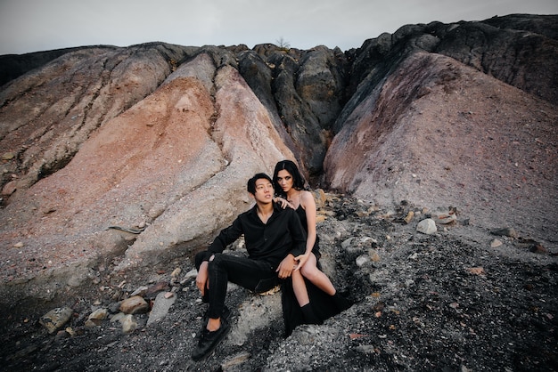 Couple asiatique amoureux embrasse assis sur les rochers. Histoire d'amour