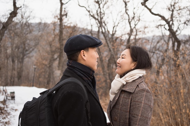 Un couple asiatique amoureux se regarde en marchant dans un parc d'hiver Portrait en gros plan