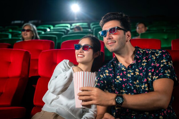 Photo un couple asiatique doux et regardant un film de comédie ensemble dans un théâtre romantique avec des lunettes 3d voyage de la saint-valentin pour la famille