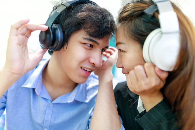 couple asiatique, écouter de la musique avec un casque bouchent