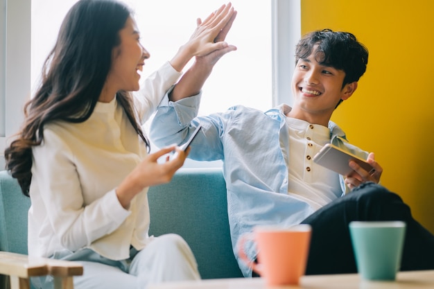 Couple asiatique jouant à des jeux à la maison ensemble, la vie heureuse d'un jeune marié