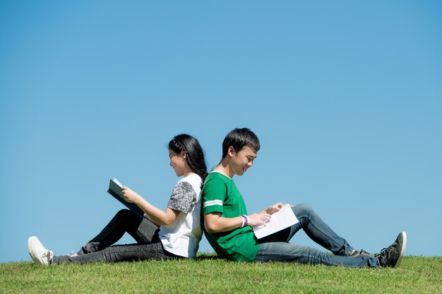 Couple asiatique, lecture livre, ensemble, à, parc extérieur