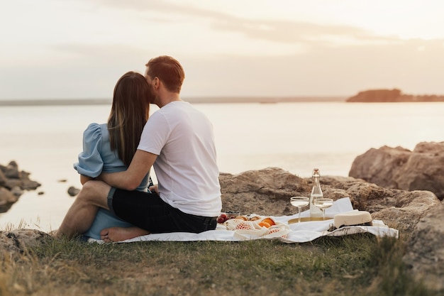 Un couple assis sur une couverture sur la plage