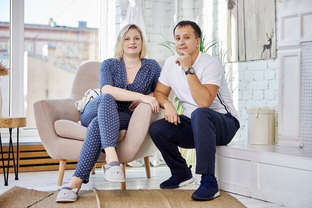 Couple assis dans le salon près de la fenêtre pendant la journée