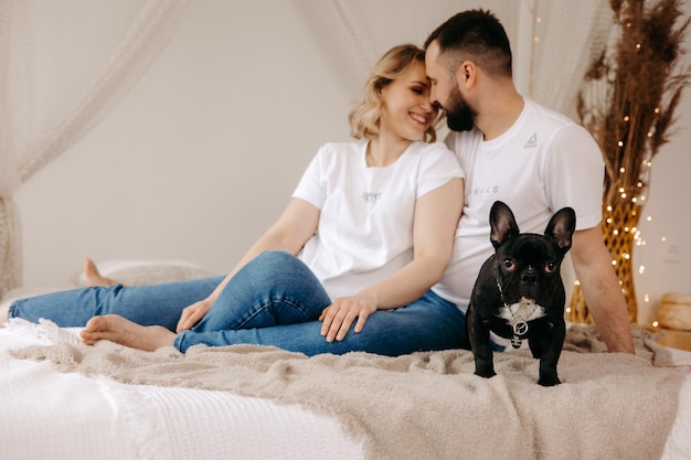 Couple assis sur un lit avec un chien sur le lit