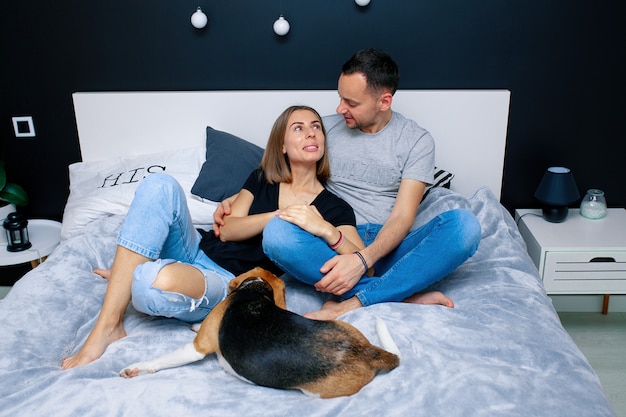 Couple assis sur un lit dans la chambre