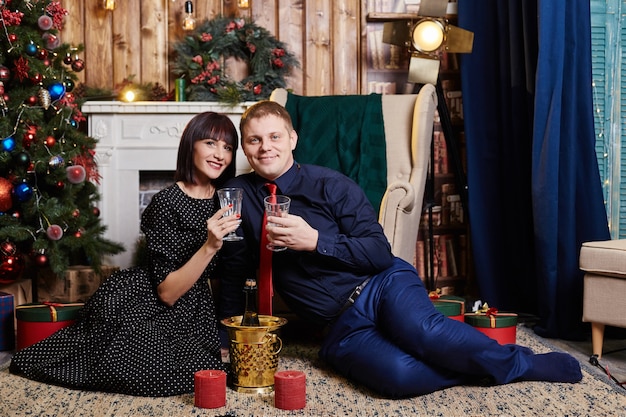 Couple assis près d'un arbre Chrsitmas