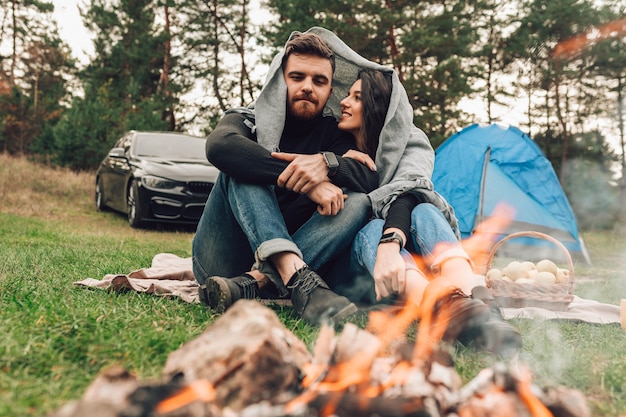 Couple assis près d'un feu de camp