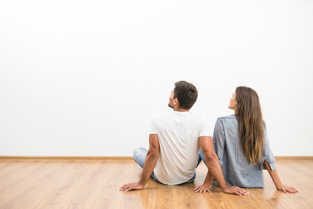 Le couple assis regarde le mur vide