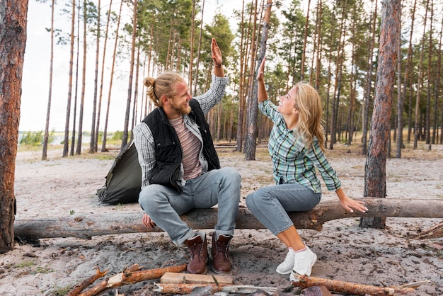 Photo couple assis sur une tige d'arbre cinq