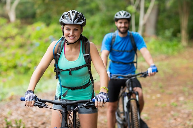 Couple athlétique à vélo dans la forêt