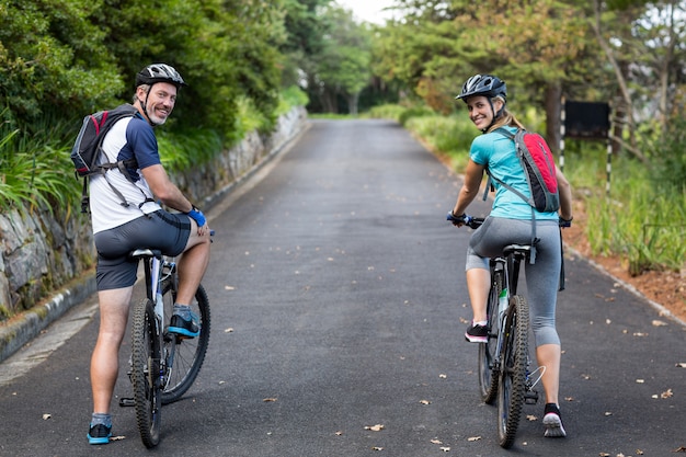 Couple athlétique à vélo sur la route ouverte