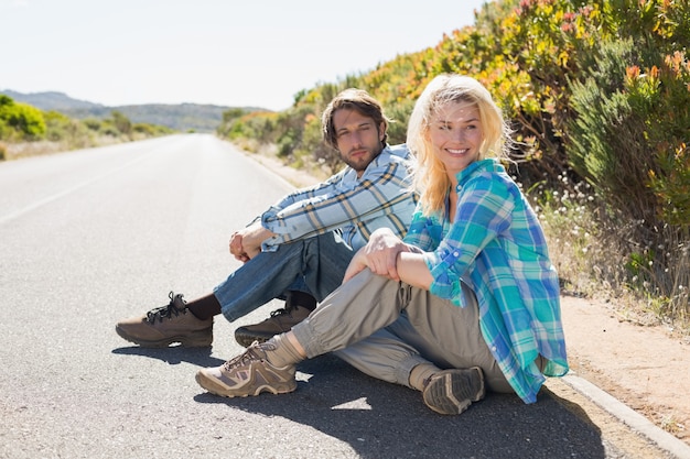 Couple attrayant assis sur la route