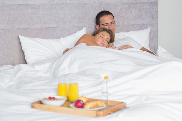 Couple attrayant, dormir avec plateau de petit déjeuner sur le lit