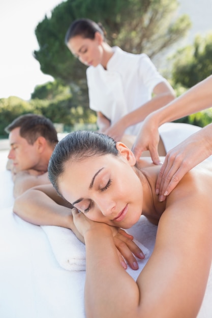 Couple attrayant profitant de couples massage au bord de la piscine