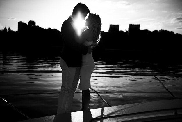 Un couple au bord du lac contre le ciel au coucher du soleil