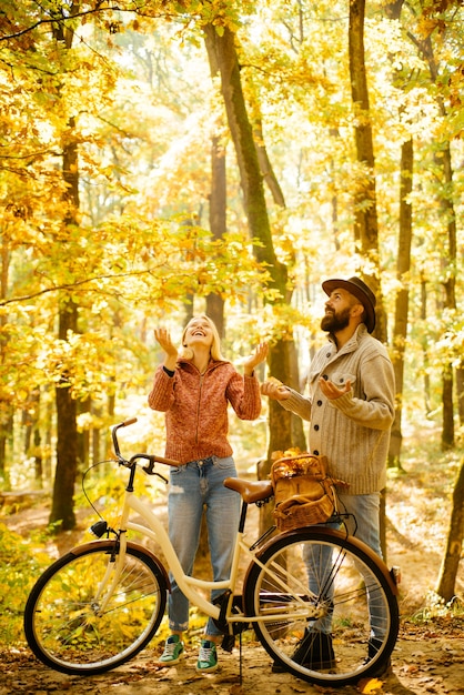 Couple d'automne fait du vélo dans le parc personnes actives à l'extérieur femme d'automne un homme barbu avec ...