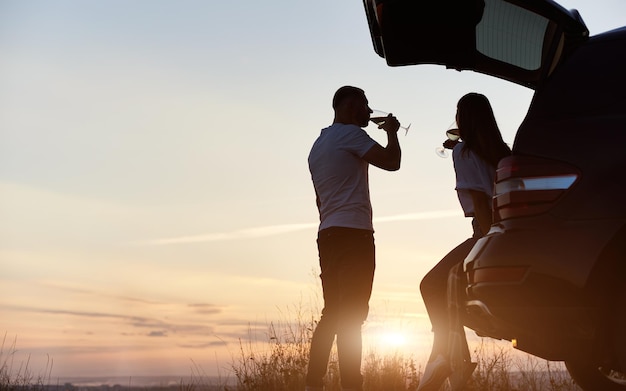 Couple ayant du vin dans le coffre de la voiture