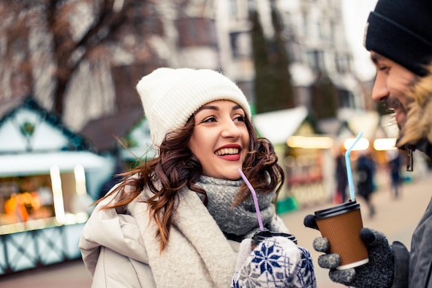 Un couple boit du café chaud à la foire d'hiver