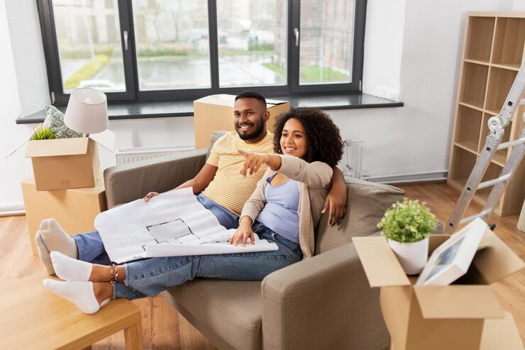Photo un couple avec des boîtes et un plan déménage dans une nouvelle maison.