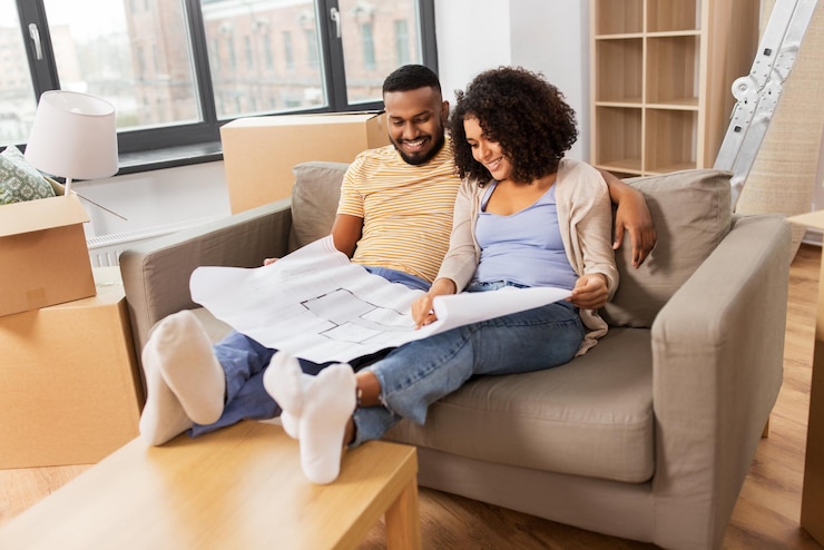 Photo un couple avec des boîtes et un plan déménage dans une nouvelle maison.
