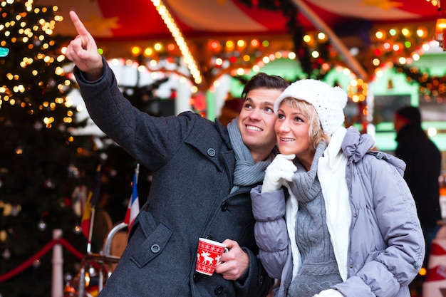 Couple buvant du vin épicé sur le marché de Noël