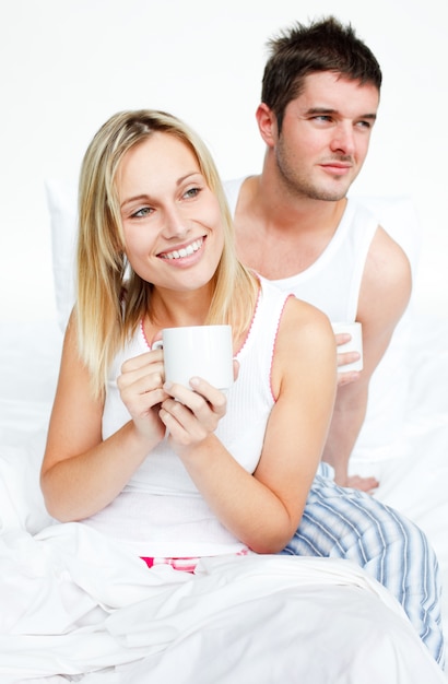 Couple buvant une tasse de thé au lit