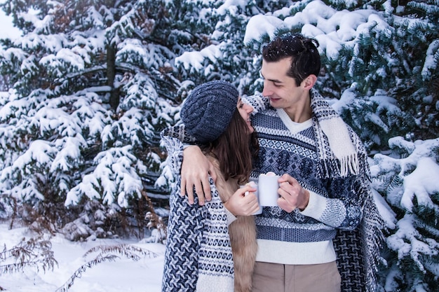 Couple câlins en forêt d'hiver