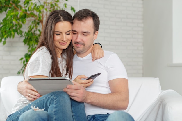 Couple sur le canapé avec tablette numérique