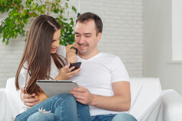 Couple sur le canapé avec tablette numérique