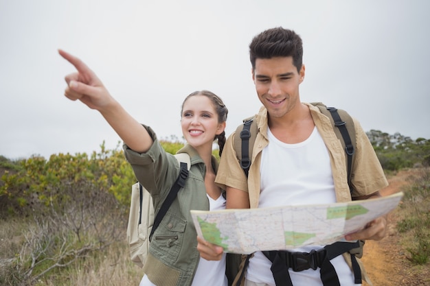 Couple avec carte pointant vers l&#39;avant sur le terrain de montagne