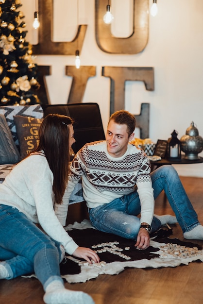 Couple célébrant Noël et jouant dans une ambiance chaleureuse à la maison