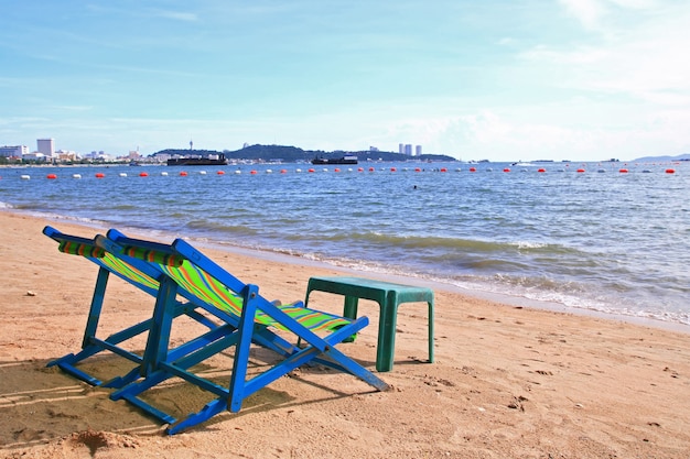 Couple de chaises de plage et table sur la plage de la ville de Pattaya