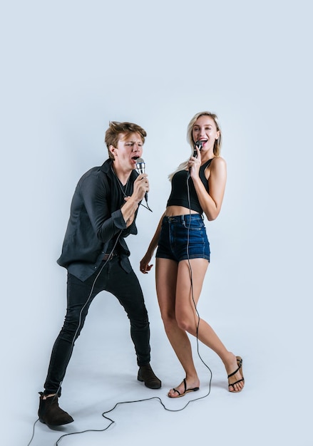 Un couple chante sur un fond blanc.