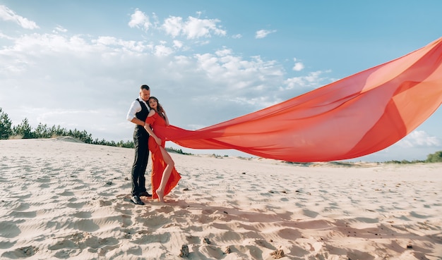 Couple charmant élégant posant sur la plage