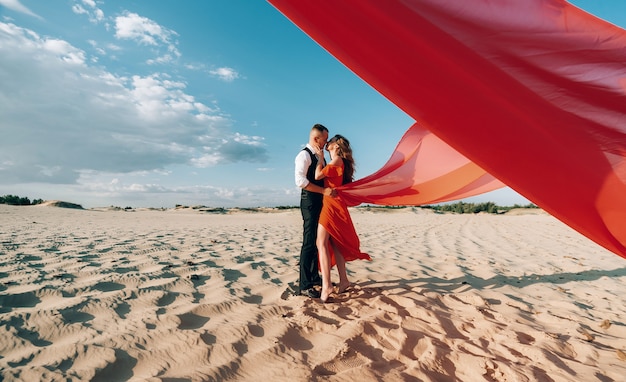 Couple charmant élégant posant sur la plage