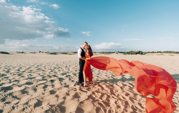 Couple charmant élégant posant sur la plage