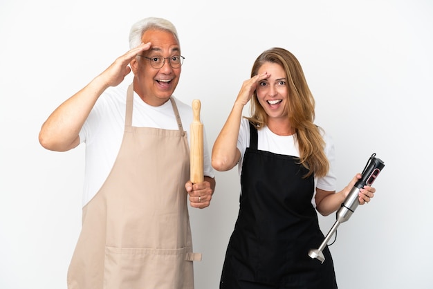 Un couple de chefs d'âge moyen isolé sur fond blanc vient de réaliser quelque chose et a l'intention de trouver la solution