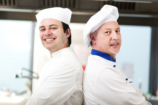 Photo couple de chefs dans la cuisine