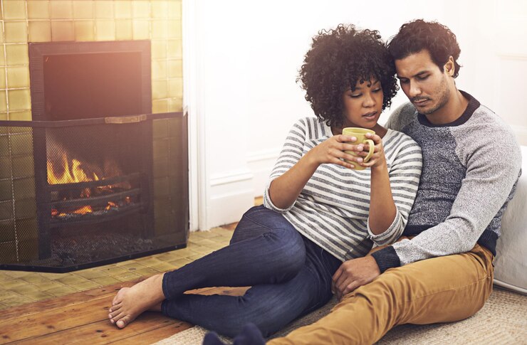Photo couple cheminée et se détendre pour les soins et la date dans la sécurité de la maison et fier du mariage et de l'engagement les gens café et l'attachement sur le sol dans le salon le week-end de soutien et de confiance dans la relation