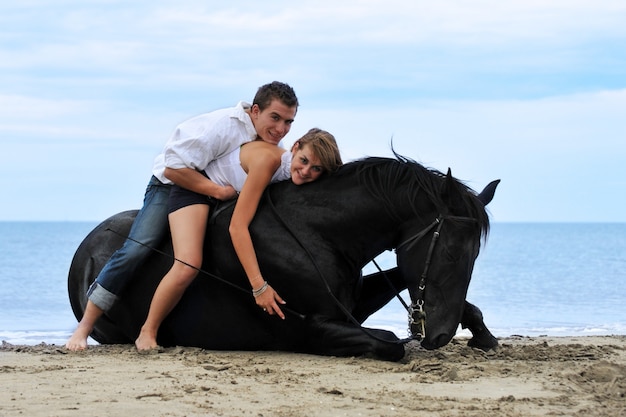 Couple et cheval sur la plage